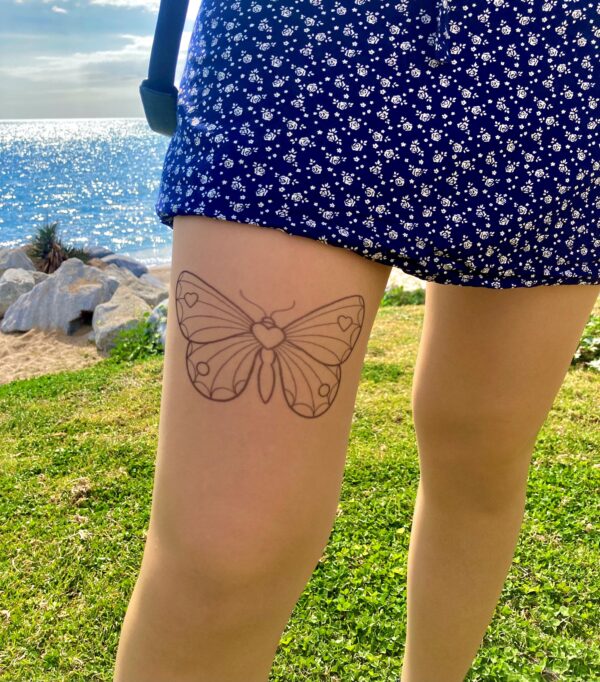 Printed butterfly design on sheer stockings, applied to the thigh