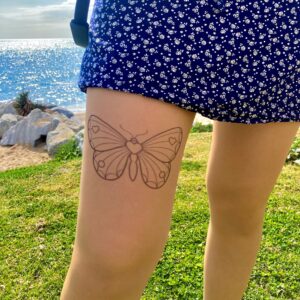 Printed butterfly design on sheer stockings, applied to the thigh