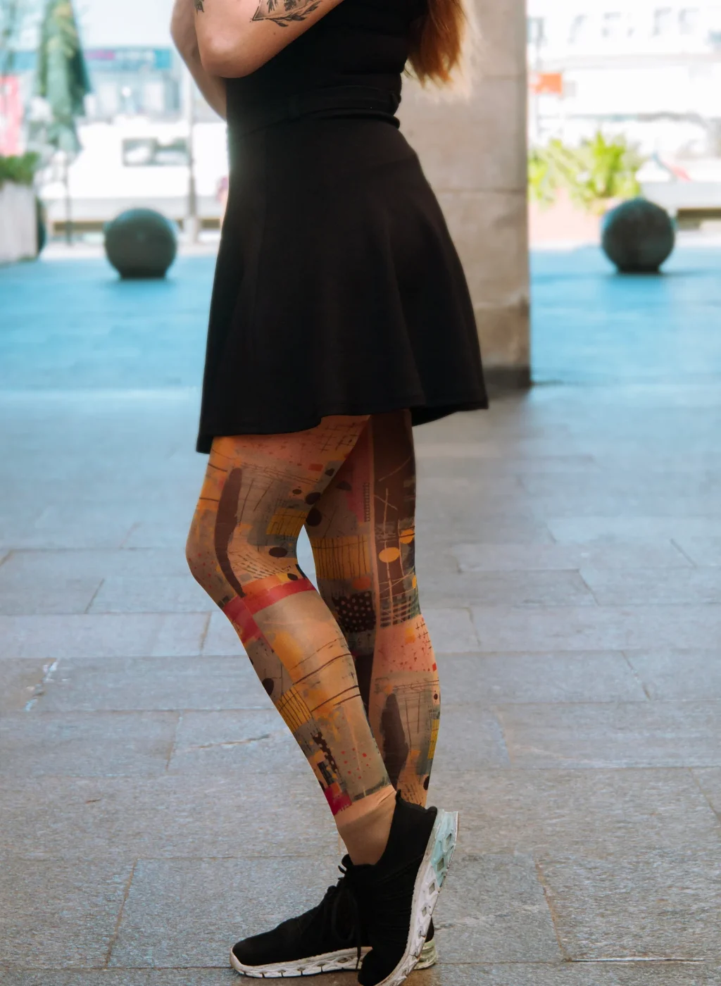 Mujer con pantimedias de arte abstracto en tonos cálidos posando con falda negra | Woman wearing warm-tone abstract art tights posing with black skirt