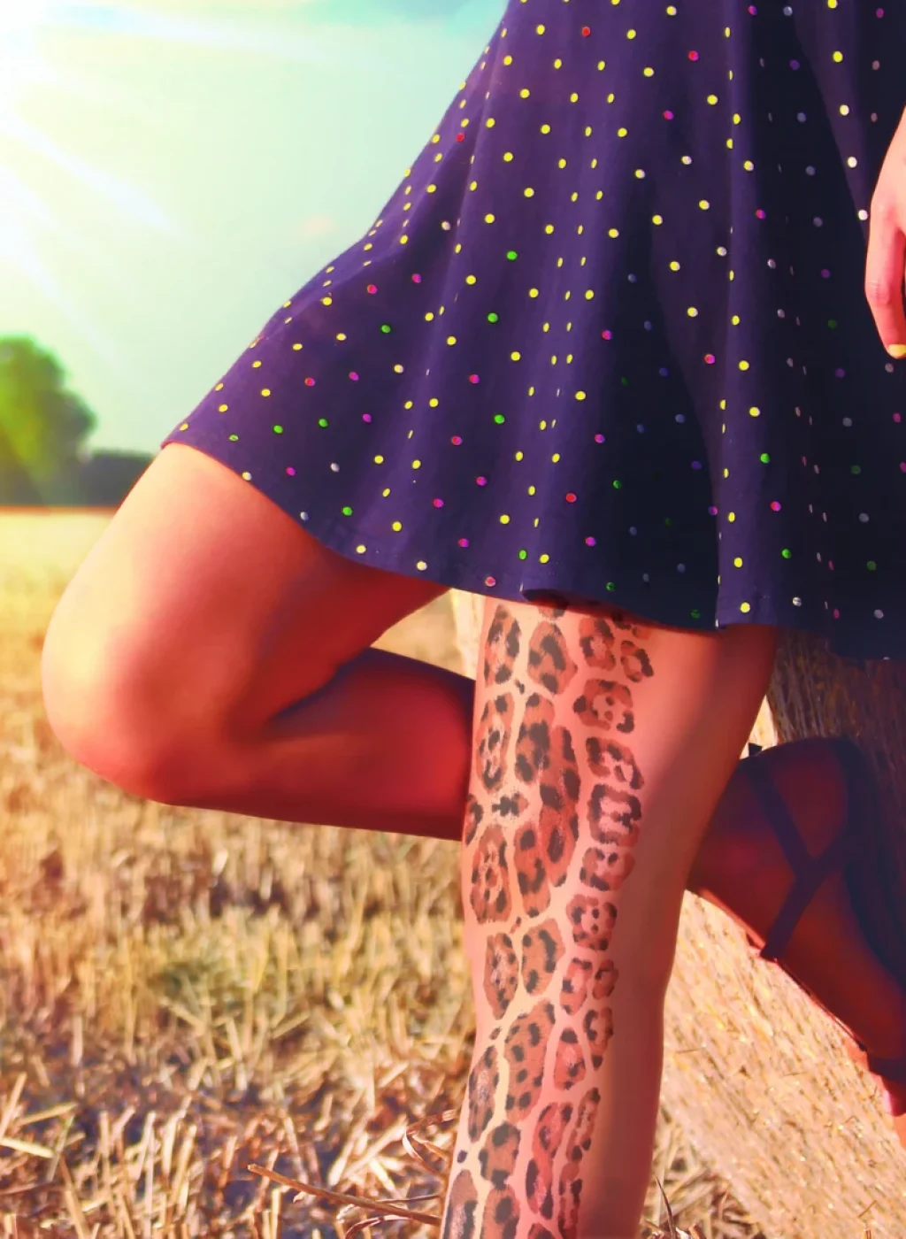 Sheer nude tattoo tights with tiger and leopard print pattern on the leg, outdoor photo with dress | Pantimedias nude semitransparentes con estampado tatuaje de tigre y leopardo en la pierna, foto exterior con vestido