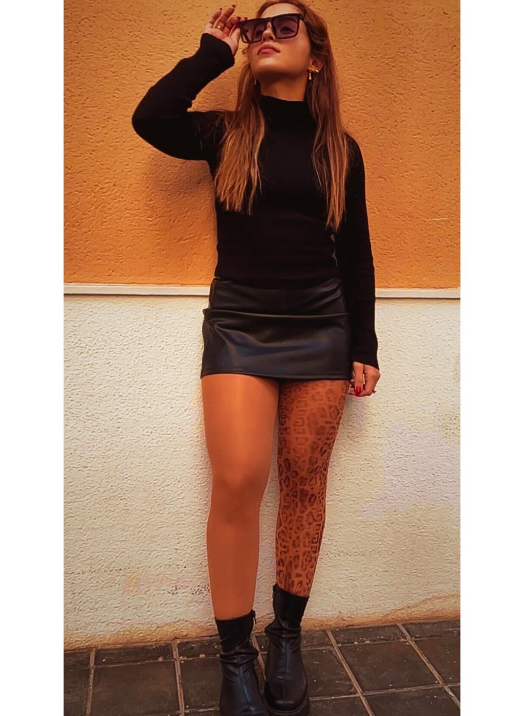 Modelo con pantimedias animal print leopardo en outfit urbano y falda negra | Model wearing leopard animal print tights in urban street style