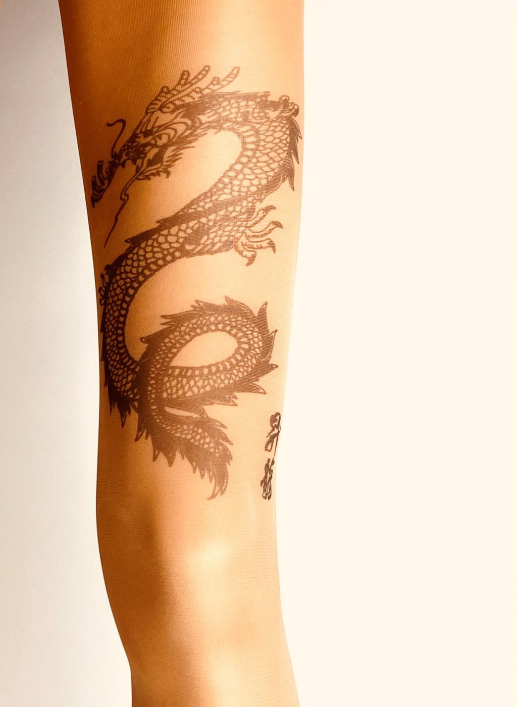 Women's nude tights printed with a "dragon" tattoo