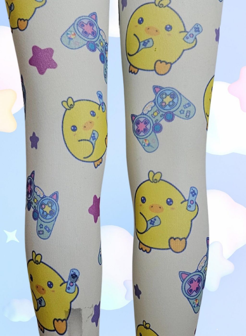 Medias infantiles blancas con dibujos kawaii de animales amarillos y estrellas, primer plano de piernas juntas sobre fondo celeste con nubes pastel. White kids tights with kawaii yellow animal and star designs, close-up of legs together on a sky blue background with pastel clouds.