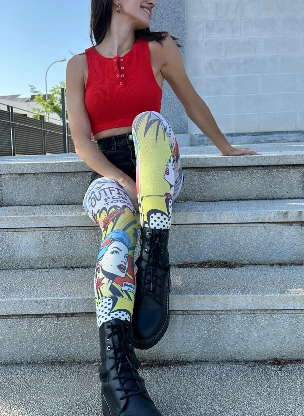 modelo sentada en unas escaleras con pantimedias cómic de colores – Oh! Tights moda pop art con top rojo y botines negros