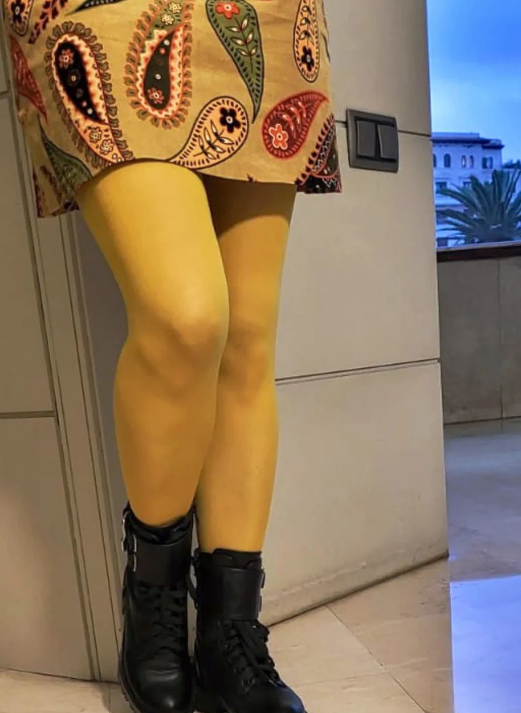 Piernas con pantimedias color mostaza combinadas con botines negros y falda estampada boho | Legs wearing mustard tights styled with black boots and a boho printed skirt