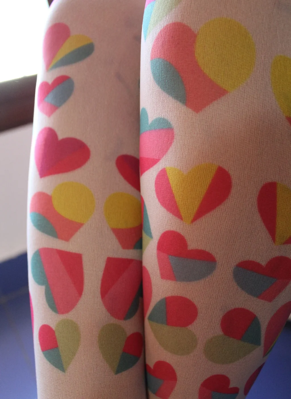 Pantimedias infantiles con estampado de corazones multicolor en primer plano | Close-up of kids tights with multicolor hearts pattern